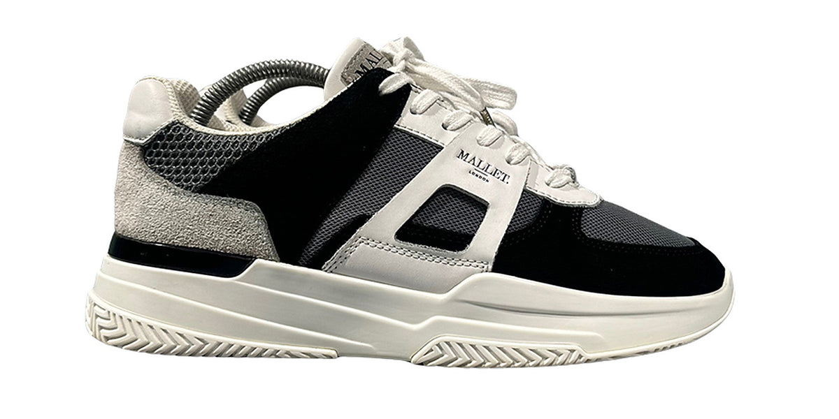 The same suede sneaker after treatment, black suede and a white midsole